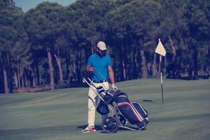 jogador de golfe andando com bolsa de rodas foto