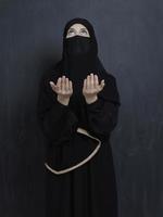 retrato de jovem muçulmana com niqab fazendo dua foto