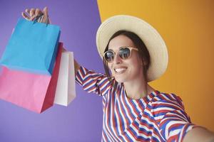 jovem mulher com sacolas de compras em fundo colorido foto