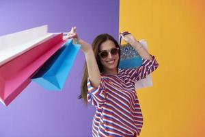 jovem mulher com sacolas de compras em fundo rosa foto