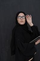 jovem empresária árabe em roupas tradicionais ou abaya segurando computador tablet foto