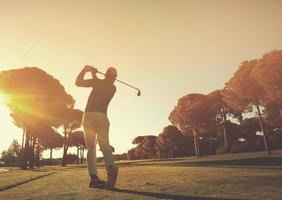 jogador de golfe batendo tiro com taco foto