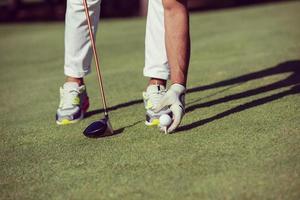 jogador de golfe colocando bola no tee foto