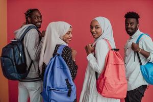 um grupo de estudantes muçulmanos africanos com mochilas posando em um fundo rosa. o conceito de educação escolar. foto