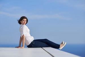 mulher relaxada na frente da casa moderna de luxo foto