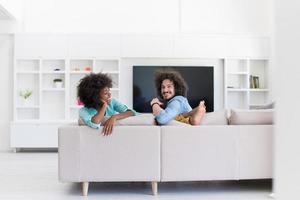 jovem casal multiétnico na sala de estar foto