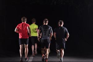 equipe de corredores no treinamento noturno foto