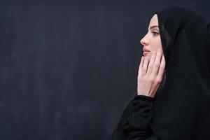 mulher muçulmana fazendo oração tradicional a deus na frente de lousa preta foto