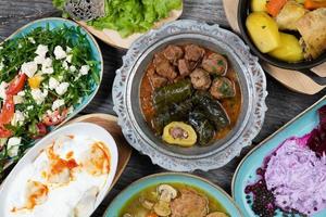 eid mubarak jantar iftar tradicional do ramadã. comida saborosa variada em autênticos pratos rústicos no fundo da mesa de madeira. foto