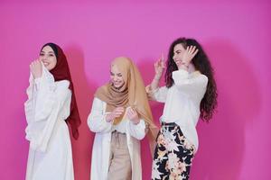 mulheres muçulmanas em vestidos elegantes isolados em rosa foto