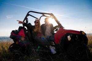 jovem casal dirigindo um carro de buggy off road foto