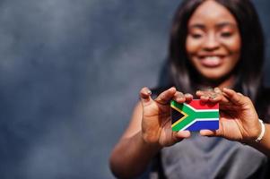 mulher africana segura pequena bandeira da áfrica do sul nas mãos. foto