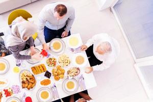 vista superior da família muçulmana multiétnica moderna esperando o início do jantar iftar foto