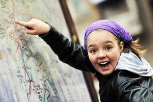 menina com painel de mapa da cidade foto