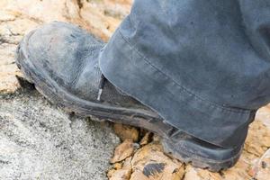 bota de couro trekking na rocha foto