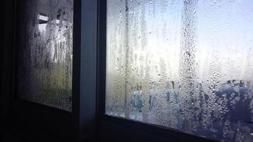 vista da janela na manhã fria com gotas de chuva de água no vidro foto