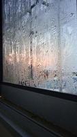vista da janela na manhã fria com gotas de chuva de água no vidro foto