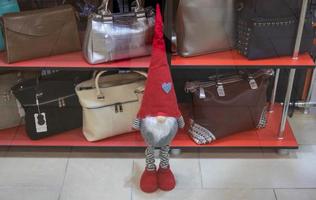 nas sacolas da vitrine e um anão com um chapéu vermelho pontudo foto