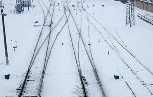 estrada ferroviária de inverno com neve branca. trilhos na neve foto