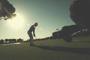 jogador de golfe acertando tiro foto