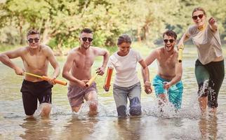 grupo de amigos felizes se divertindo no rio foto