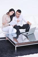 casal alegre relaxa e trabalha no computador portátil em casa moderna