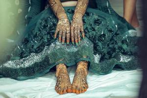 design natural de henna mehndi nas mãos e pés da noiva durante o casamento hindu foto