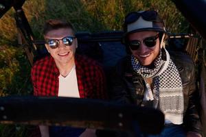 dois jovens felizes animados desfrutando de um belo dia ensolarado enquanto dirigia um carro de buggy off road foto