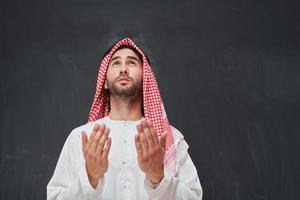 homem árabe em roupas tradicionais orando a deus ou fazendo dua foto