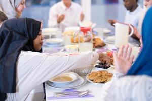 mulher muçulmana moderna negra desfrutando do jantar iftar com a família foto