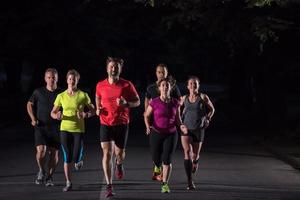 equipe de corredores no treinamento noturno foto