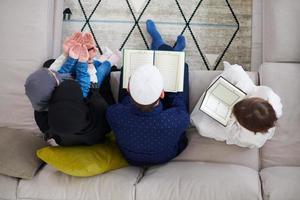 família muçulmana lendo o alcorão e orando em casa vista superior foto