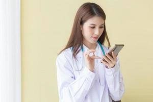 médica asiática usando um telefone celular
