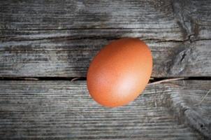 um ovo de galinha marrom fora de foco em um fundo de madeira, vista superior, minimalismo foto