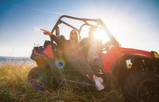 jovem casal dirigindo um carro de buggy off road foto