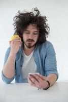 jovem comendo maçã e usando um celular em casa foto