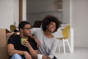 casal americano africano relaxando em casa nova foto