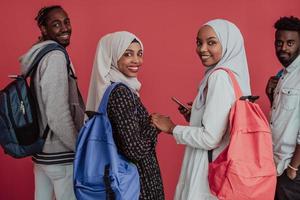 um grupo de estudantes muçulmanos africanos com mochilas posando em um fundo rosa. o conceito de educação escolar. foto