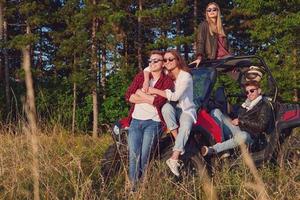 grupo jovens felizes desfrutando de um belo dia de sol enquanto dirigia um carro de buggy off road foto