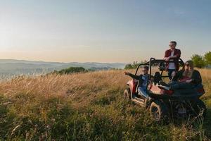 grupo jovens felizes desfrutando de um belo dia de sol enquanto dirigia um carro de buggy off road foto