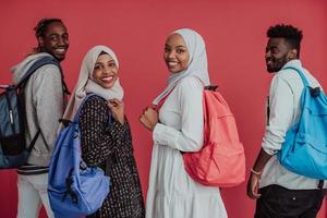 um grupo de estudantes muçulmanos africanos com mochilas posando em um fundo rosa. o conceito de educação escolar. foto