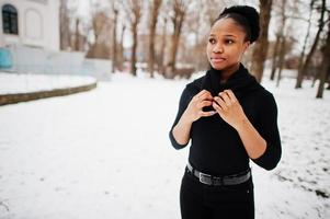 mulher africana usa em pose toda preta em dia de inverno na europa. foto