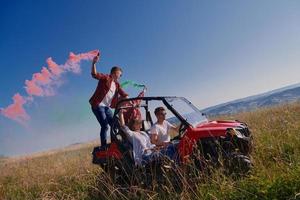 pessoas animadas se divertindo aproveitando um belo dia ensolarado segurando tochas coloridas enquanto dirigia um carro de buggy off road foto