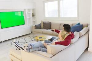 jovem casal no sofá assistindo televisão foto