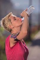 mulher bebendo água depois de correr foto