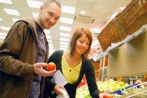 casal feliz comprando frutas no hipermercado foto