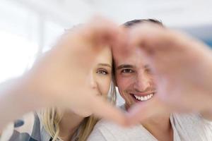 casal fazendo coração com as mãos foto