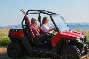 meninas desfrutando de um lindo dia ensolarado enquanto dirigia um carro off-road foto