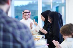 família muçulmana tradicional rezando antes do jantar iftar foto