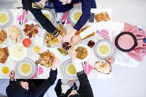 família muçulmana jantando iftar comendo datas para quebrar a vista superior da festa foto